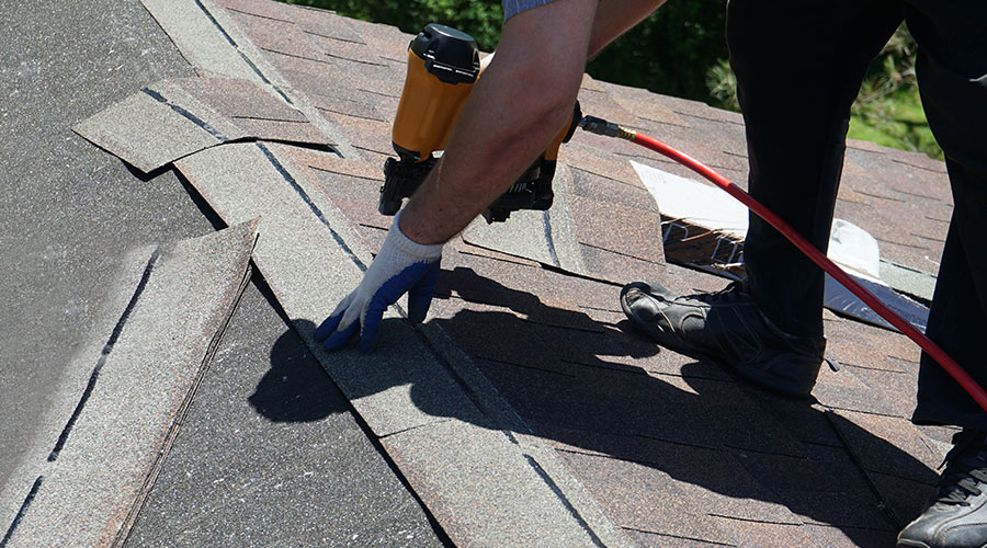 man installing roof shingles