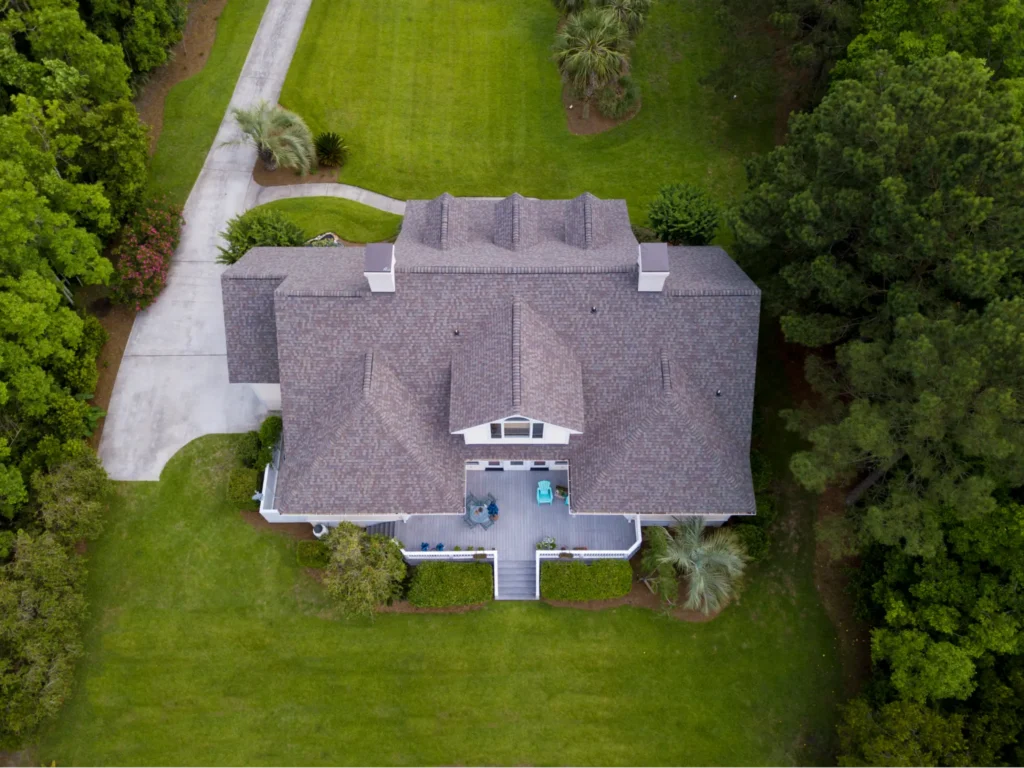 Drone view looking down at large home with shingle roof